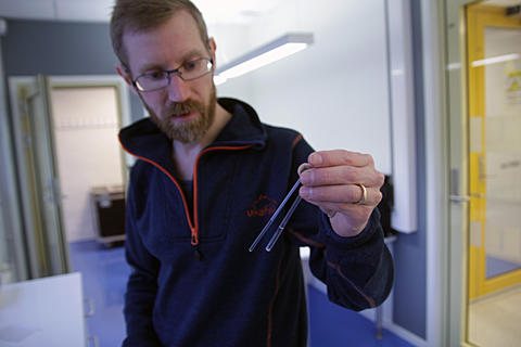Jarl Underhaug, førsteamanuensis ved kjemisk institutt og fagansvarlig ved den norske NMR-plattformen ved UiB, viser fram kolbene som NMR-spektrometeret analyserar.
