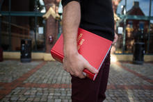 En student holder en lovsamling under armen. 