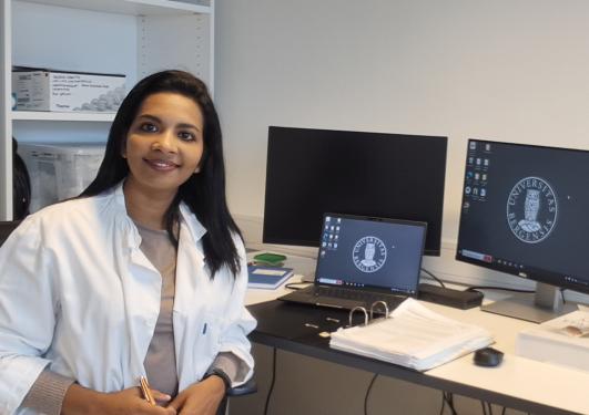 Young woman sitting at computer smiling at camera