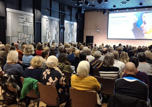 Sal med mange deltakere.