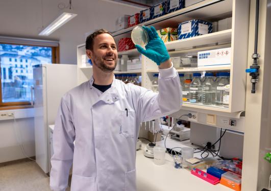 Researcher in the laboratory holding a petri dish