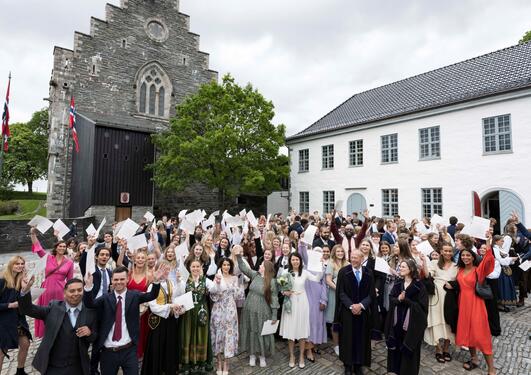 Alle bachelorkandidater ca 220 stykker, samlet i borregården ute ved Håkonshallen. Mange ler og holder diplomet over hodet.