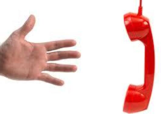 Håns som strekker seg mot et rødt telefonrør