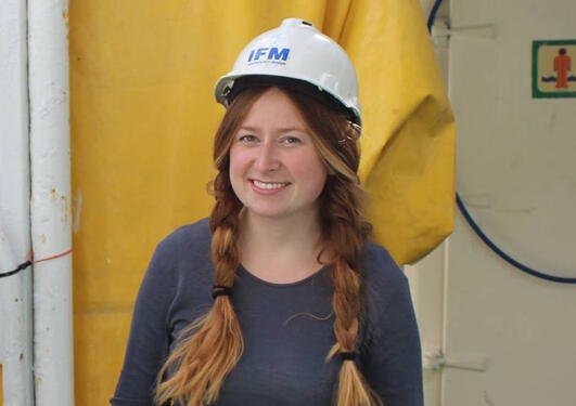 Photograph of a woman with helmet on board a research vessel