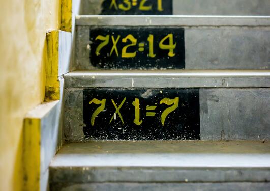 A staircase with the 7 times table painted on the steps