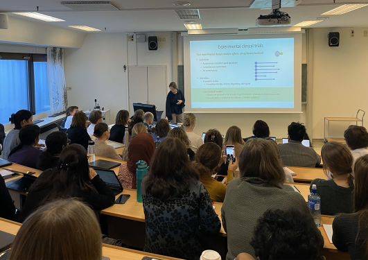 Speaker on stage, in front of a room fiull of course participants.