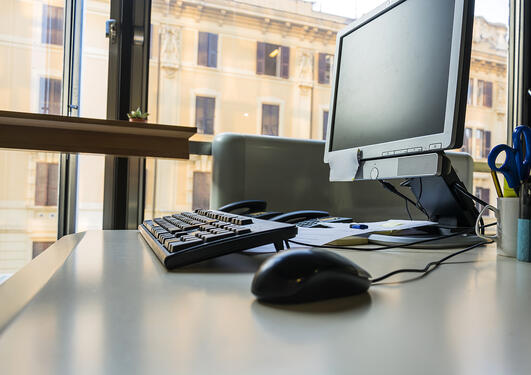 Bilde av kontorarbeidsplass med tastatur, mus og skjerm.