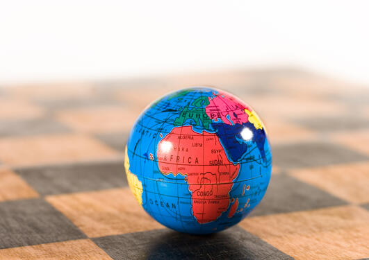 Small globe on an old wooden chessboard