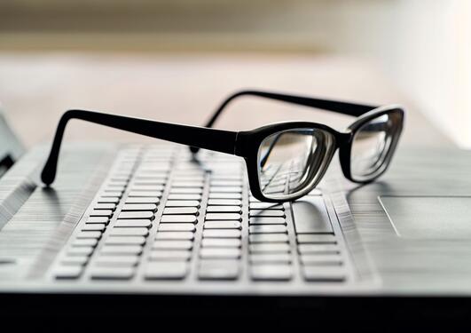 Bildet viser briller på et tastatur