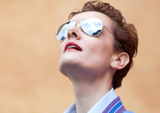 Woman with sunglasses looking up in the sky 