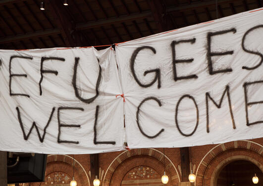 Klede hvor det står "refugees welcome" foran en bygning