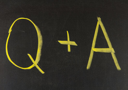 Q + A written on a blackboard.