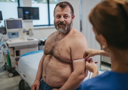 person med fedme på sykehus, får målt overarmtykkelse av en sykepleier