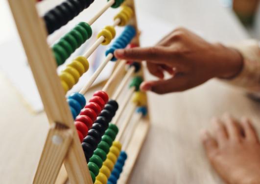 Hands counting on an abacus