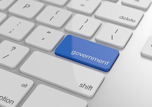 Keyboard showing the shift key marked in blue with the imprint “government”. Used to illustrate news article about e-government.