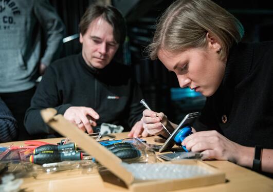 Student Anja Myrtveit repairing her mobile phone at a workshop on Day Zero during the 2019 SDG Conference Bergen.