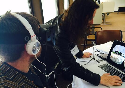 A man wearing an Oculus Rift visor and headphones experiences a work of electronic literature at ELO2014.