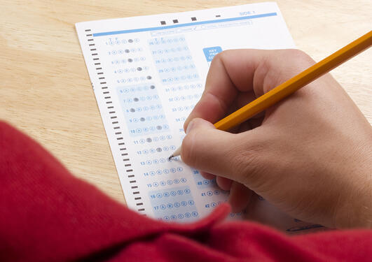 Boy fills out exam papers