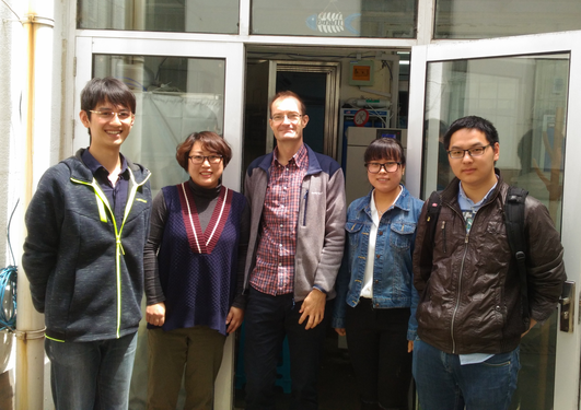 Group photo of five people in front of the laboratorium