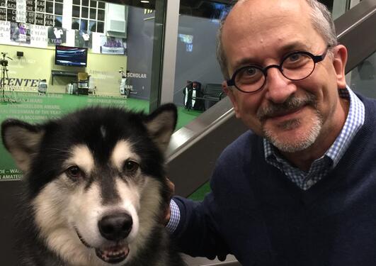 Franklin Furlong at one of The University of Washington (UW) Men's Basketball team's matches. The accompanying husky dog is the school mascot of UW.