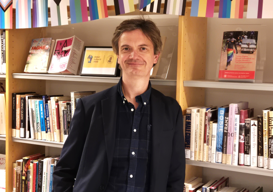 Prisvinner Frode Helmich Pedersen foran bokhylle.