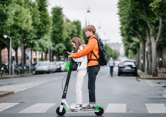 Two young people riding an electric scooter