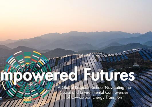 Text: Empowered Futures, solar panels and mountains in the background