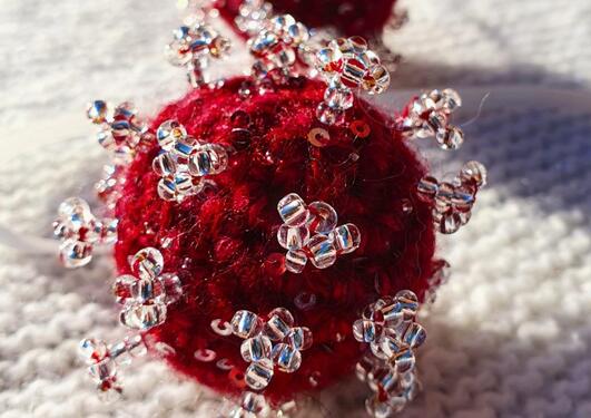 Heklet og perlebrodert SARS-CoV-2-virus.