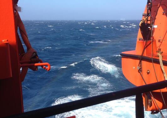 View from a vessel towards blue sea with some white wave tops