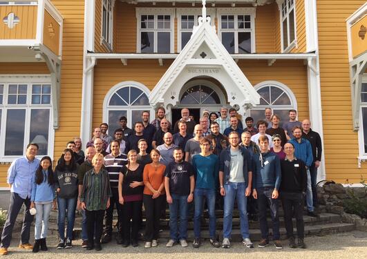 The image depicts the participants of the Operations Research and Parameterized Complexity Workshop, held at Solstrand Hotel, Bergen between 17 and 18 September 2018. The participants are grouped along a staircase with the hotel in the background.