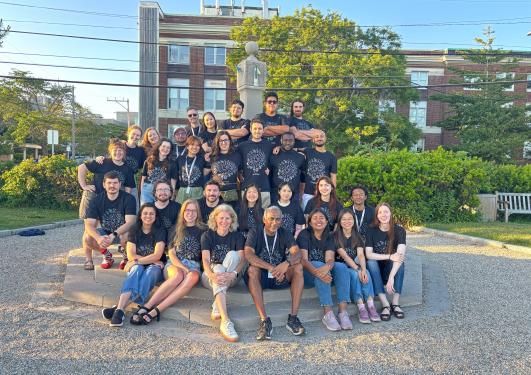 A group of student in an outdoor setting, all wearing the same t-shirt