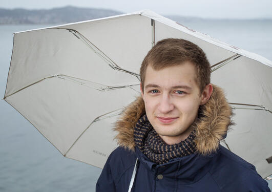 Aleksei outside with an umbrella