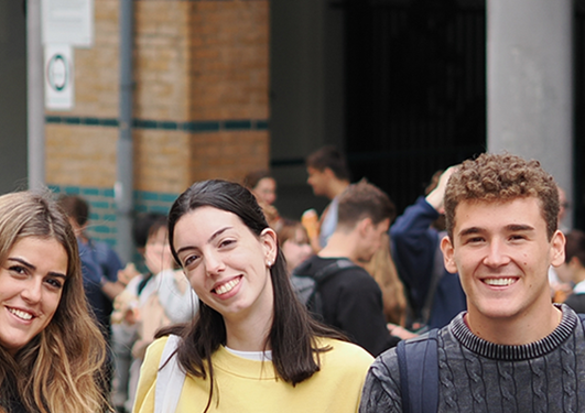 Fire smilende studenter utenfor SV-fakultetet
