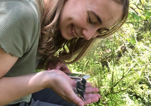 Young lady holding a bird chick in her hand