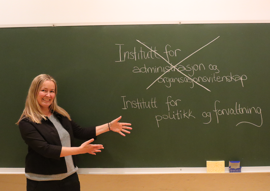 Instituttleder Lise H. Rykkja viser frem det nye instituttnavnet: Institutt for politikk og forvaltning