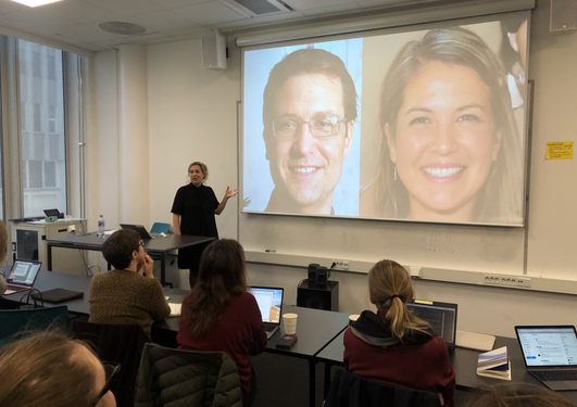 Taina bucher lectures while gesturing at her powerpoint slide displaying two algoritmically created portrait 'photographs'