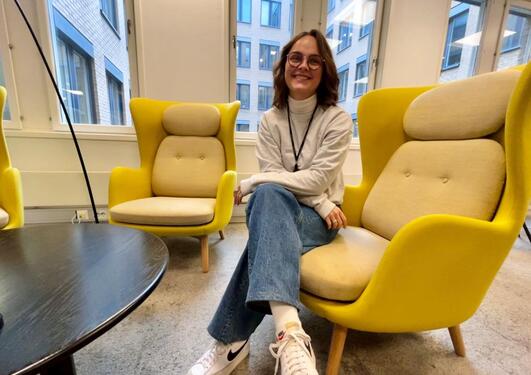 Bilde av Nora som sitter i en gul stol