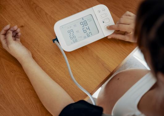 bilde av en gravid kvinne som måler blodtrykket sitt