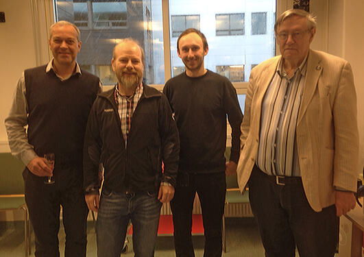 Ørjan Totland, John-Arvid Grytnes, Alistair Seddon, and John Birks standing in a line in a meeting room