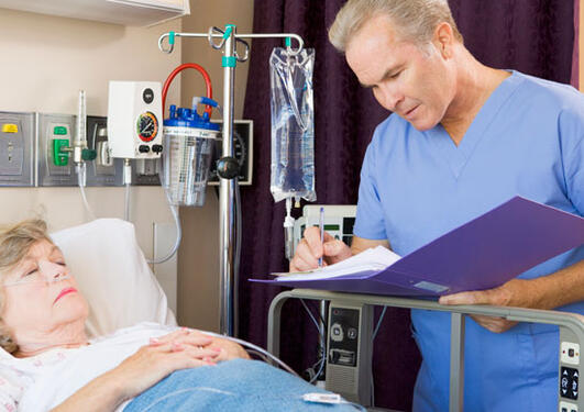 concerned doctor with patient at hospital looking at journal.