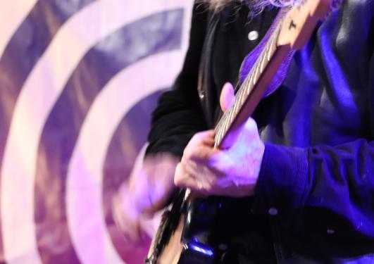 overkroppen til ein person som speler gitar