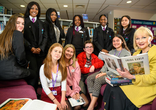 Griselda Pollock sits with students and holds a book about Frida Kahlo