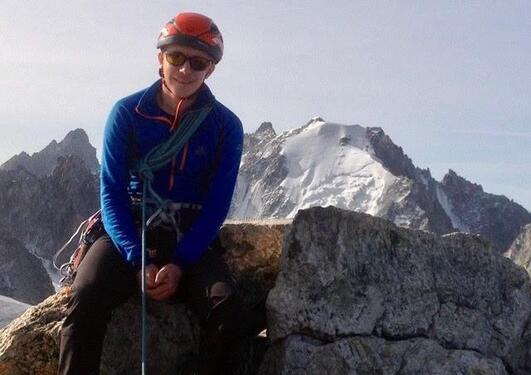 Richard Payne in climbing gear sitting on a rock 