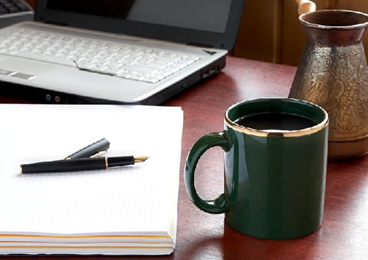 Bilde av skriveblokk, laptop og kaffekopp