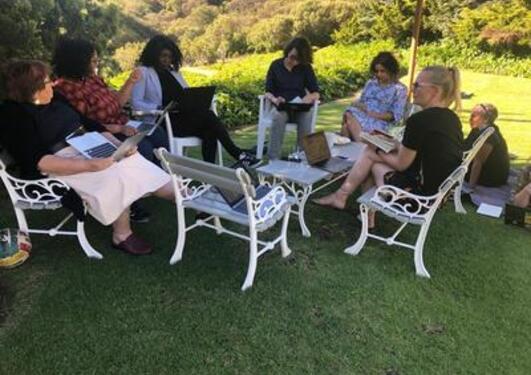 Researchers of the project gathered outside in a green area, discussing