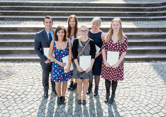 Seks studenter i solskinnet etter at de har mottatt vitnemålet sitt under Vitnemålsseremonien 2014