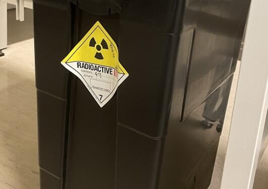 svarte avfallsbeholdere med klistremerke for radioaktivt innhold