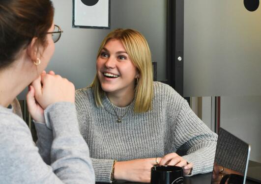 To jenter sitter ved et bord