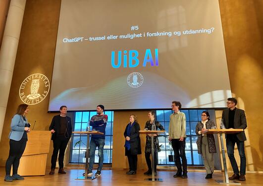 Paneldeltakere på scenen i Universitetsaulaen i Bergen i diskusjon om AI