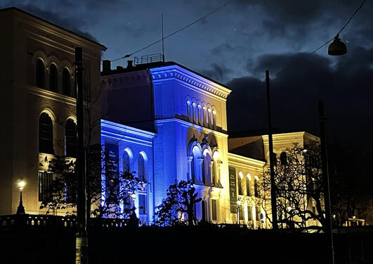 Bilde av Universitetsmuseet lyst opp i blått og gult 